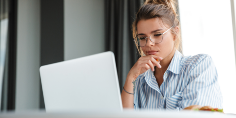 Woman at laptop, thinking